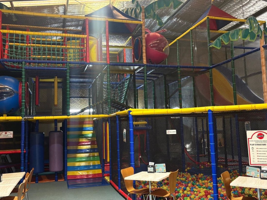 Three-storey play structure with red, yellow, and blue slides at Rumble Tumbles Albury
